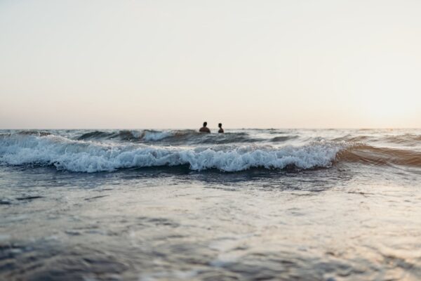 2 People Surfing on Sea Waves