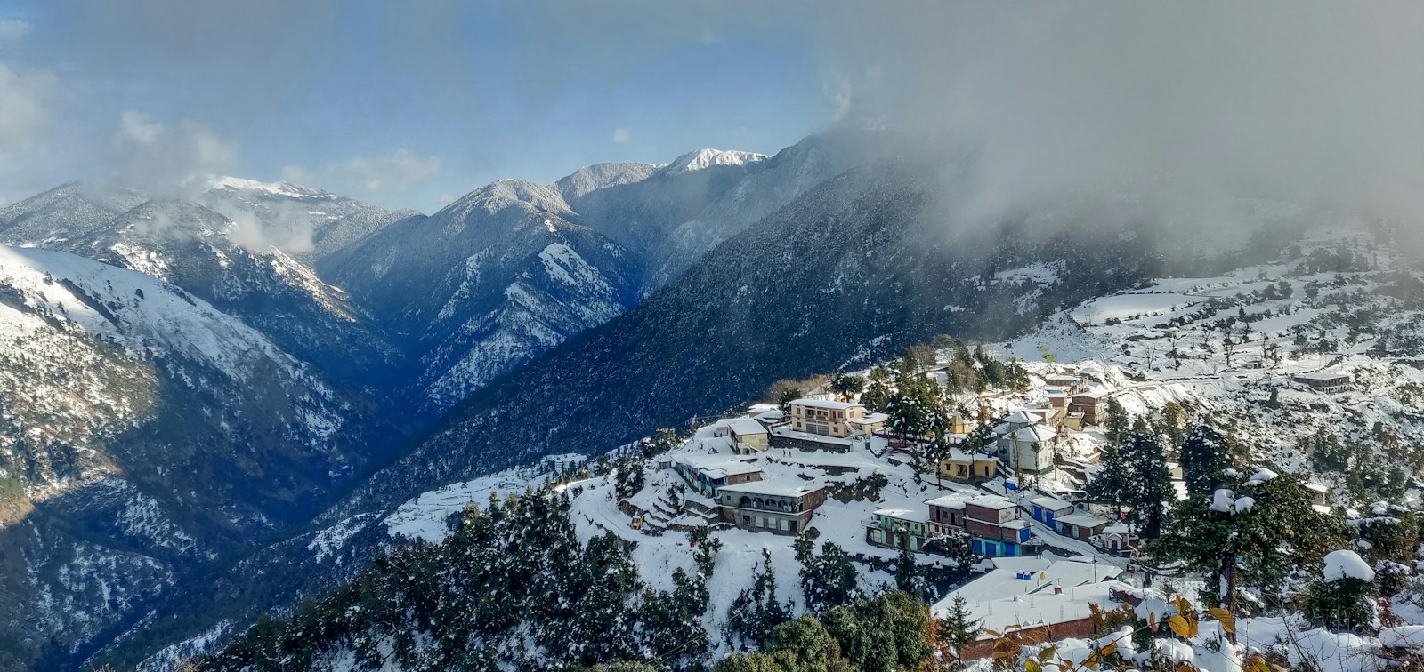 white and brown houses on snow covered mountain during daytime